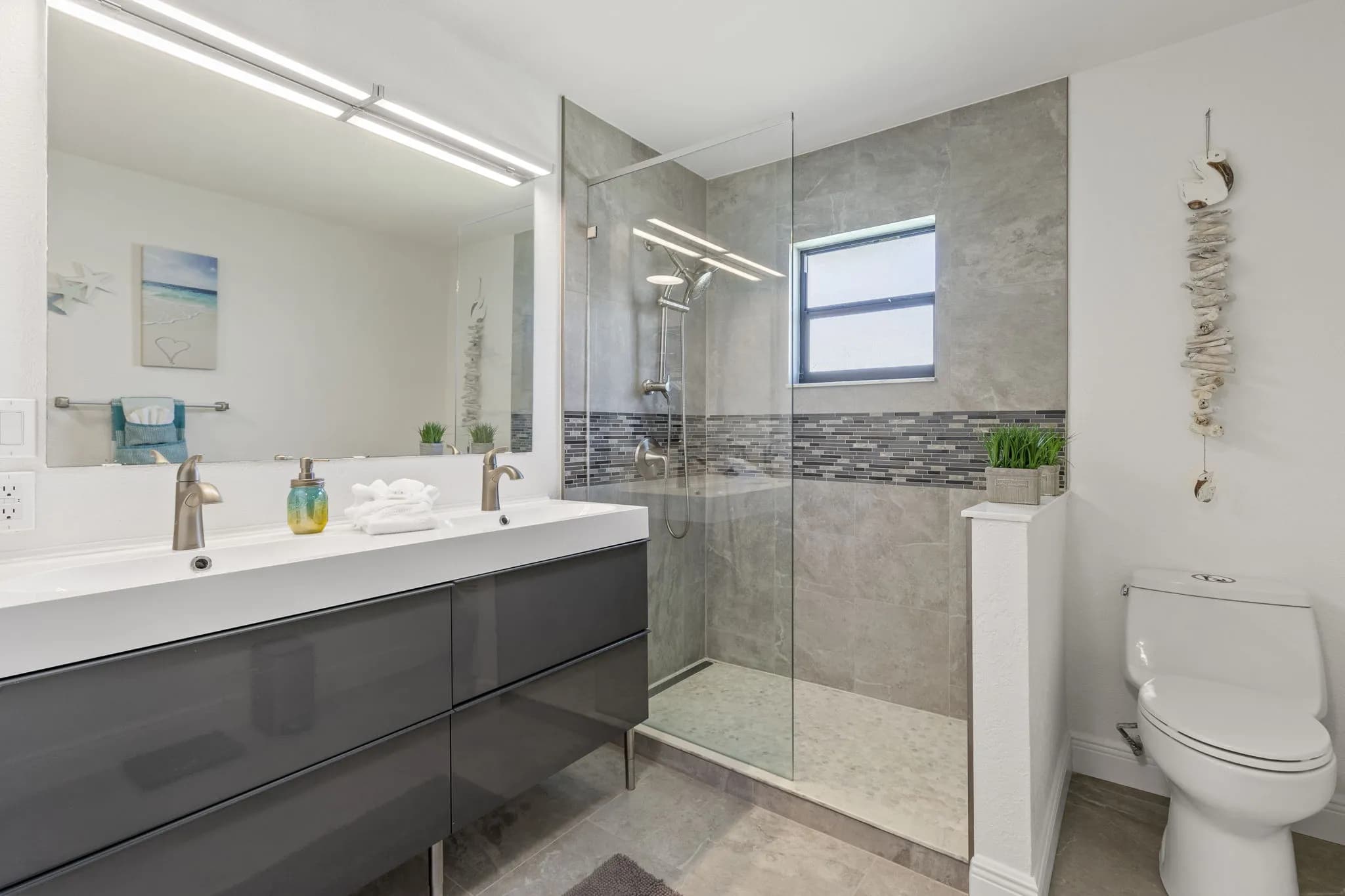 Gästebad mit Doppelwaschtisch, Toilette und Glasdusche