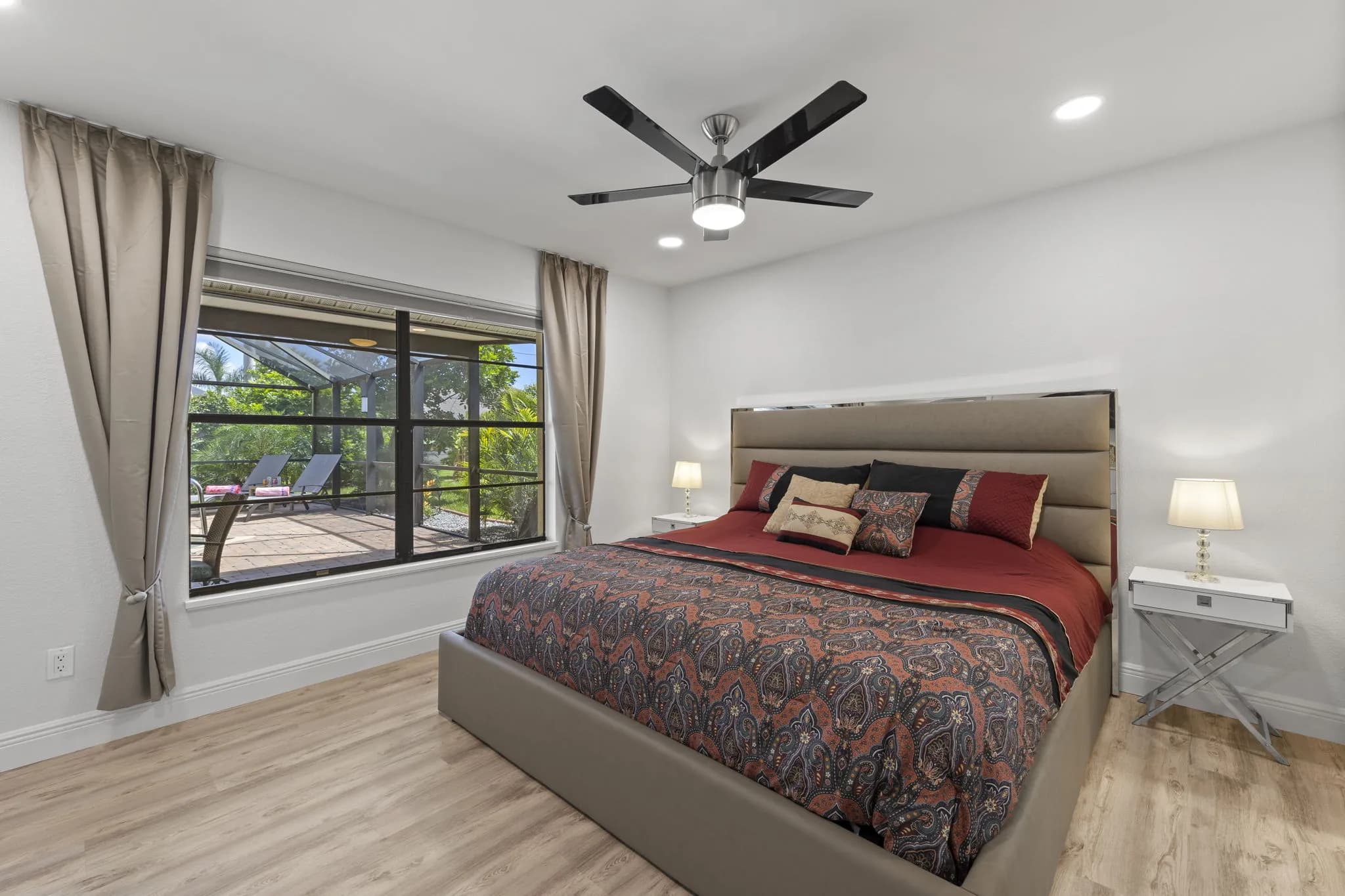 Hauptschlafzimmer mit Kingsize-Bett und Fenster zur Poolterrasse
